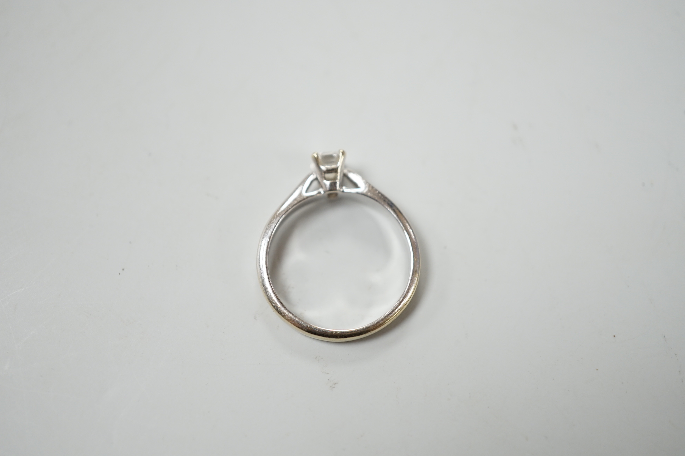 A 750 white metal and solitaire emerald cut diamond ring, size J/k, gross weight 2.9 grams.